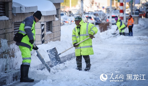 哈爾濱市區(qū)內(nèi)環(huán)衛(wèi)工人正在清雪。人民網(wǎng)記者 蘇靖剛攝