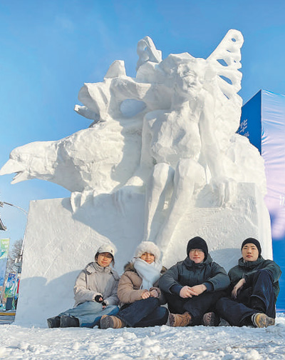 　哈爾濱工程大學雪雕隊部分成員在作品前合影。