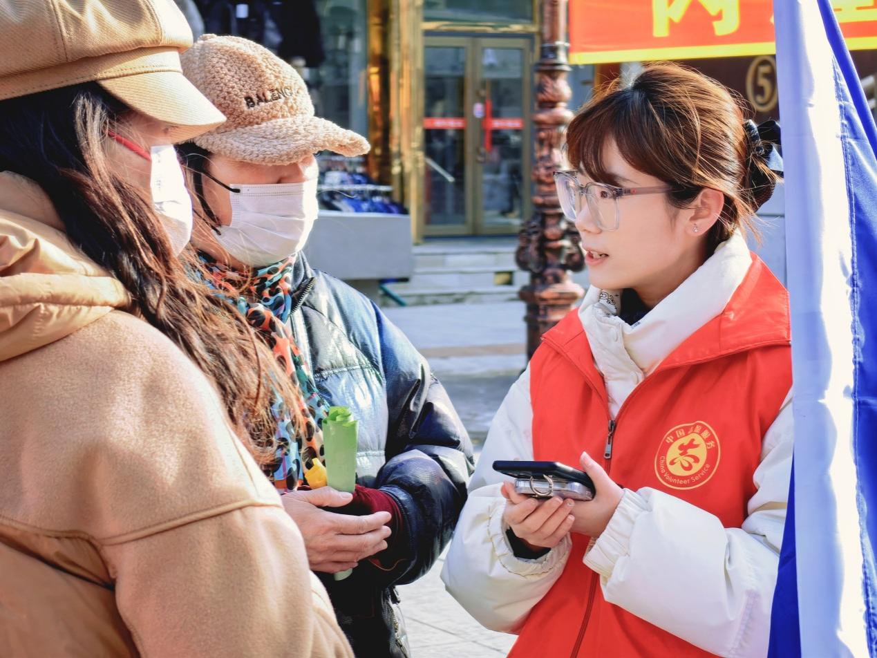 中國建設銀行伊春分行青年志愿者向市民介紹金融產(chǎn)品。